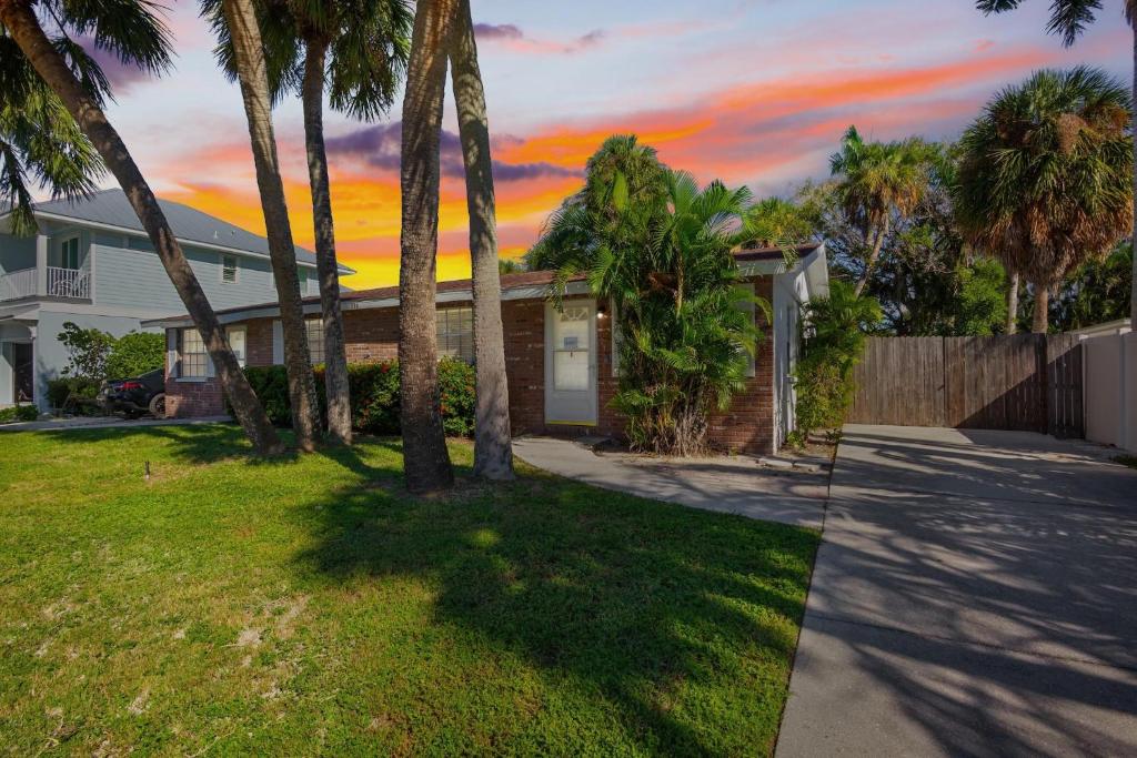 a house with palm trees in a yard at Gulf Haven East in Anna Maria Island