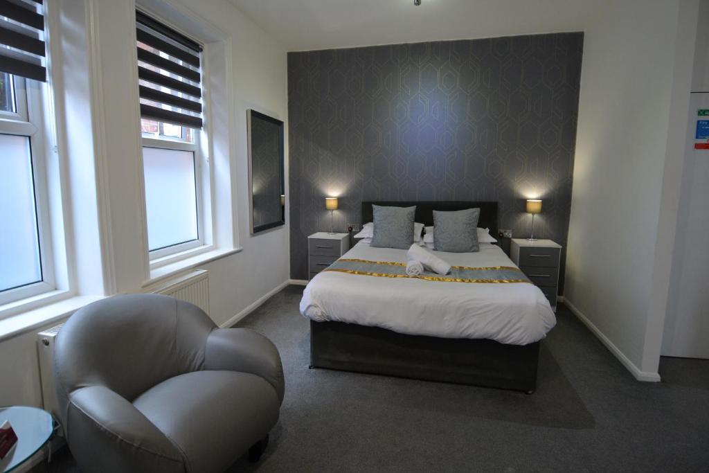 a bedroom with a bed and a chair in it at Hotel 33 in Blackpool