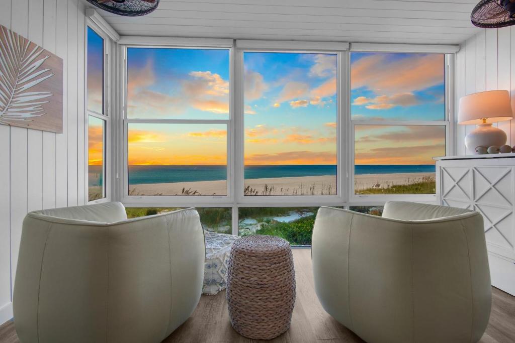 een kamer met 2 stoelen voor een groot raam bij Shimmering Shores in Anna Maria Island