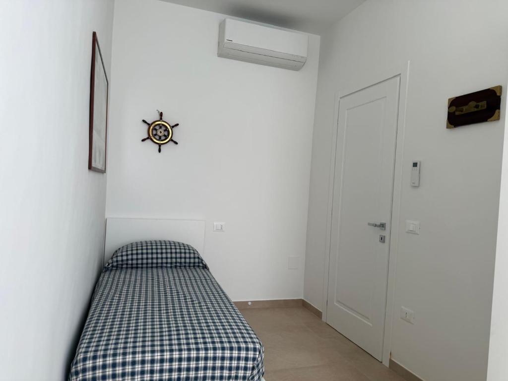 Un dormitorio con una cama en una habitación blanca. en Casa al mare di Nonno Robi, en Fano