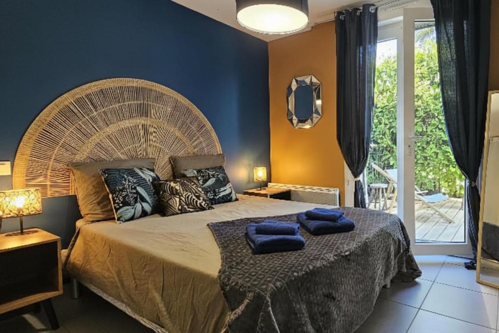 a bedroom with a large bed with blue towels on it at Nid confort proche du canal du midi 2 terrasses Labège in Labège