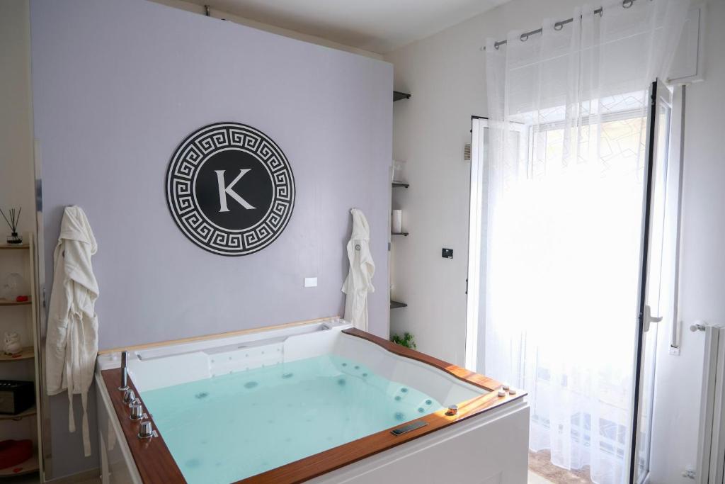 einen Whirlpool in einem Zimmer mit einem Schild an der Wand in der Unterkunft Kosmosuite in Brindisi