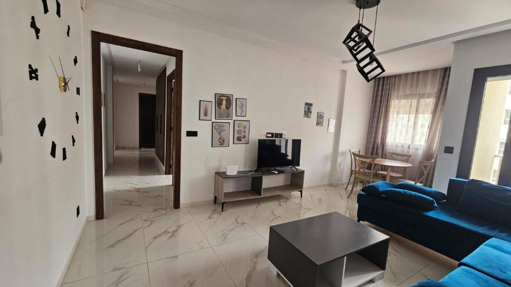 a living room with a blue couch and a table at حي الواحات in Tunis