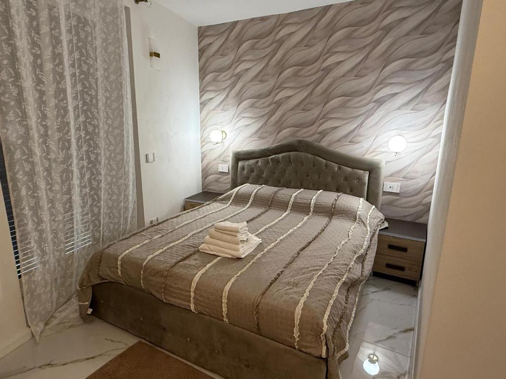 a bedroom with a bed with two night stands next to it at Holiday Home - Si Do Relais in Pozzuoli
