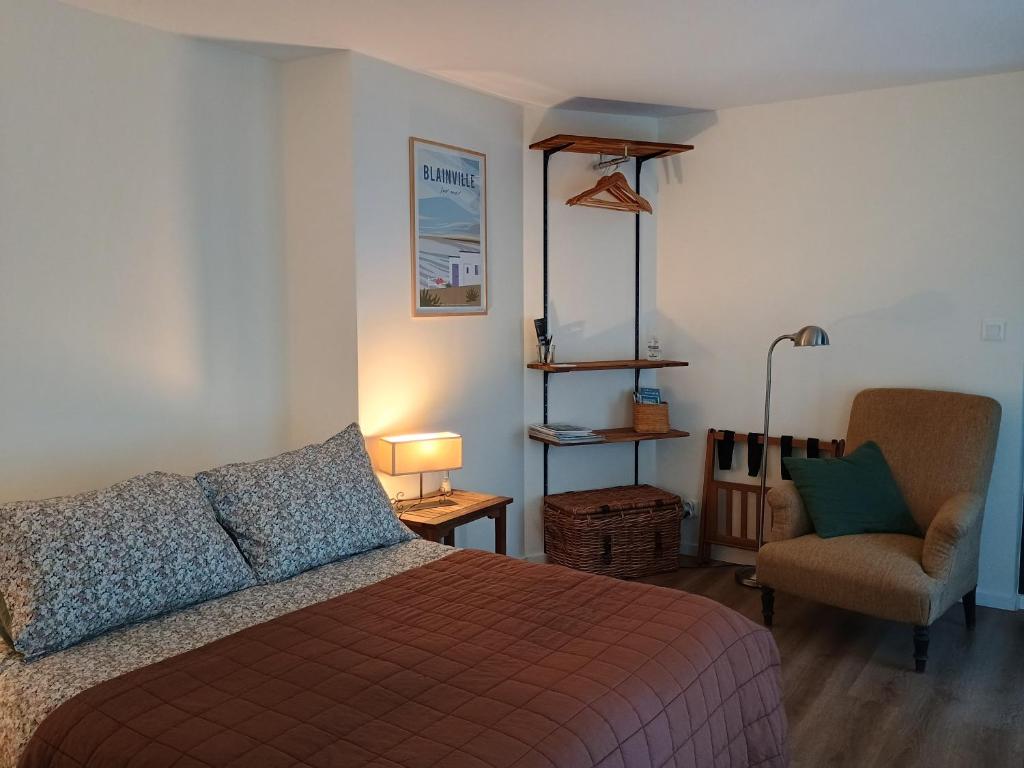 une chambre avec un lit et une chaise dans l'établissement Agréables chambres indépendantes - Coutances centre, à Coutances