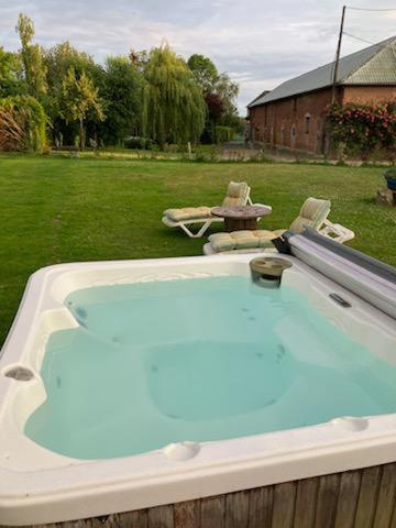 a hot tub in a yard with two chairs at Grandes Molaises in Les Hogues