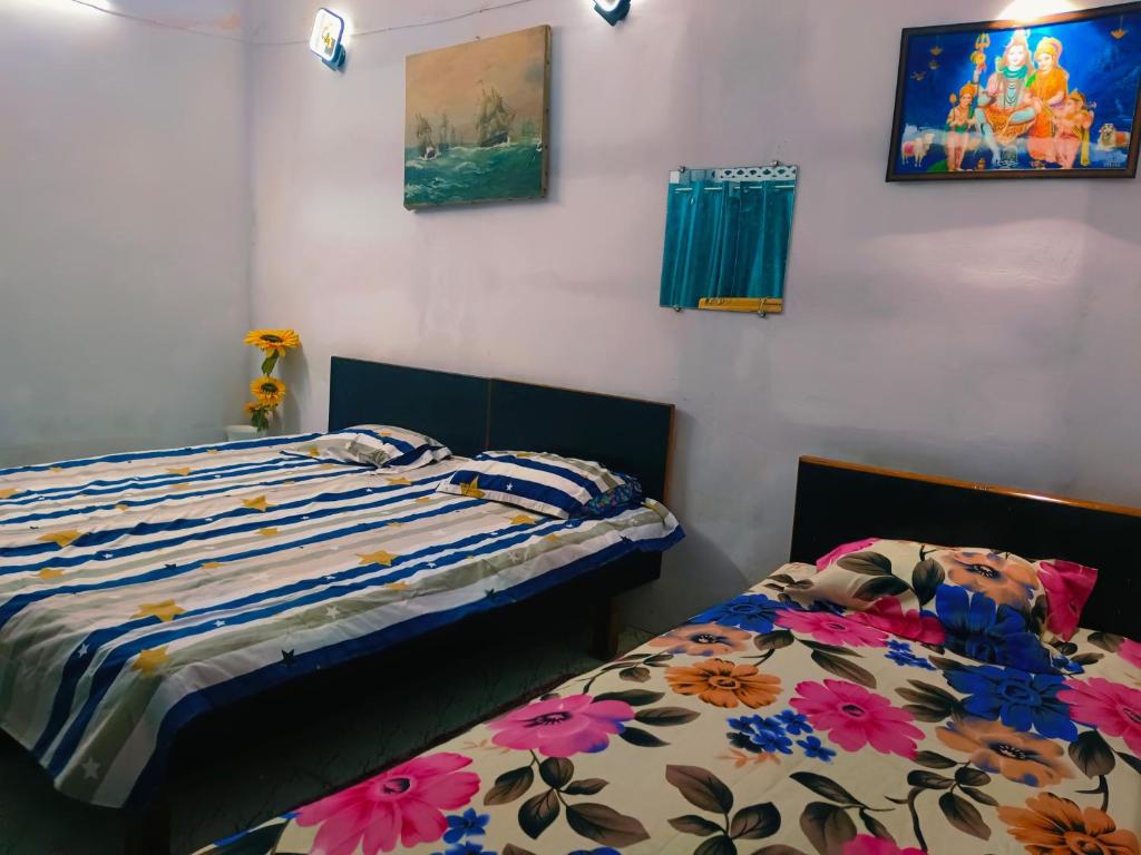 a bedroom with two beds with flowers at Kanchan Lata Homestay in Banāras Cantonment