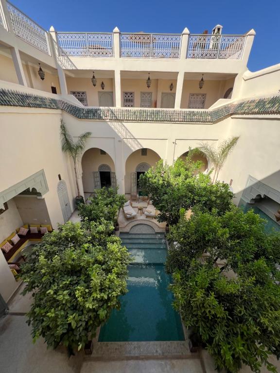- une vue extérieure sur un bâtiment avec une piscine dans l'établissement Riad Emberiza Sahari, à Marrakech