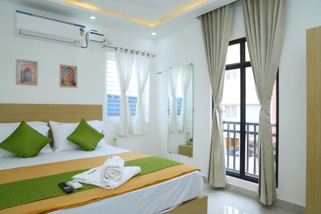a bedroom with a bed and a large window at Hotel Aeroview Near Chennai Airport in Chennai