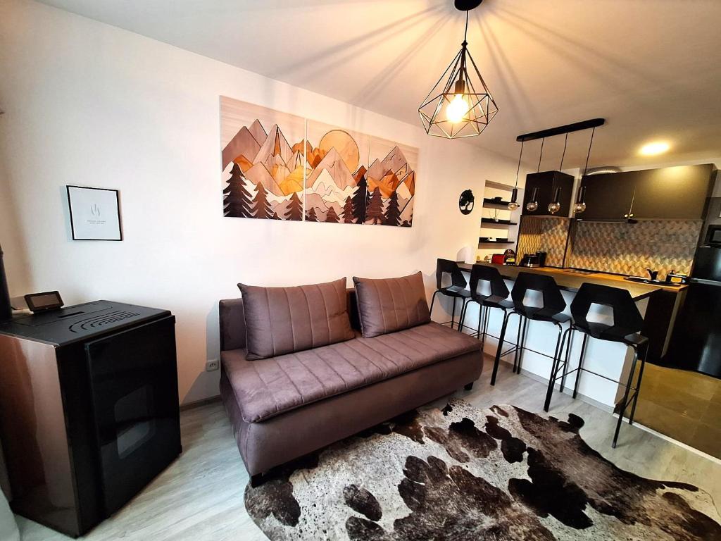 a living room with a couch and a table at Deer House - Self Check-in & Free Parking in Buşteni