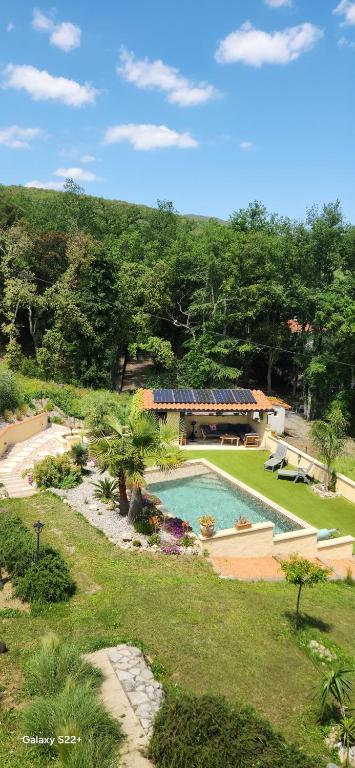 La Solentinamé في Reynès: حديقة خلفية مع حمام سباحة ومنزل