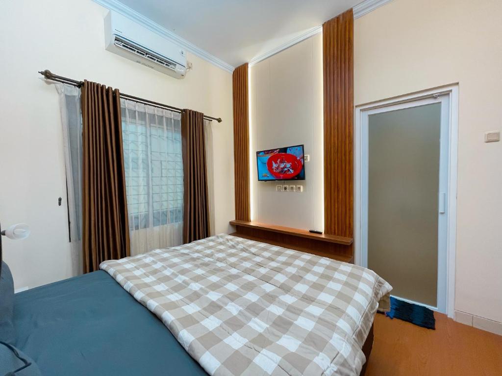 a bedroom with a bed and a window in it at Sighma Palem Merah Gejayan Premiere in Kejayan