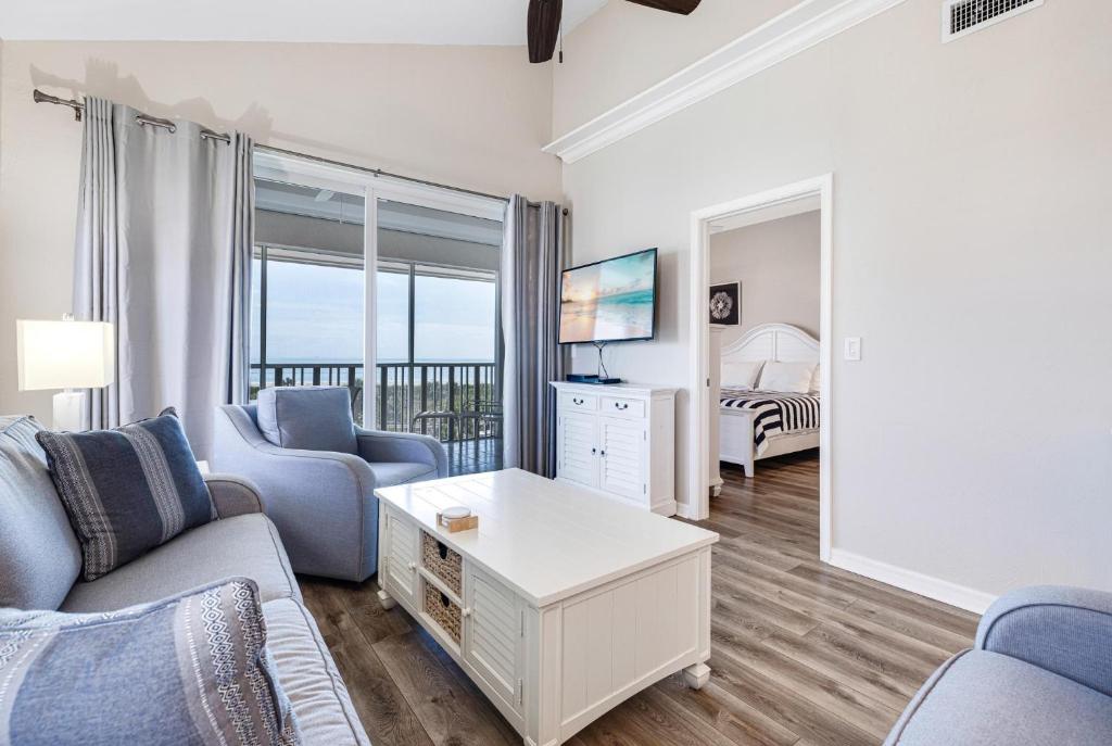 a living room with a couch and a tv at Shell Island Beach Club 7C in Sanibel