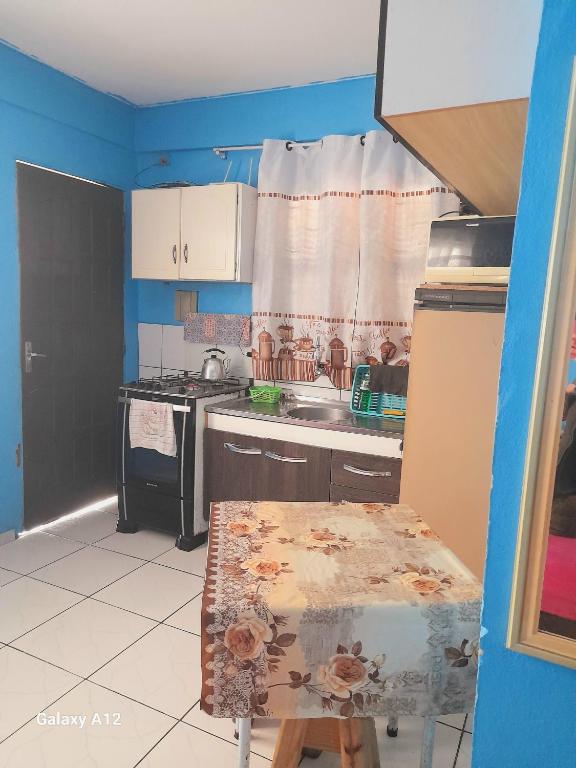 una cucina con lavandino e tavolo di kitnet Conjugado em Tramandai a Tramandaí