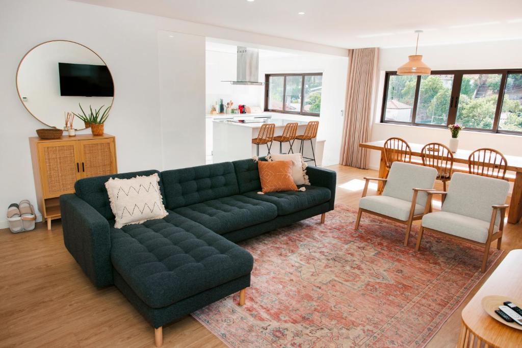 a living room with a green couch and a dining room at In the heart of Ponte da Barca, cozy apartment in Ponte da Barca