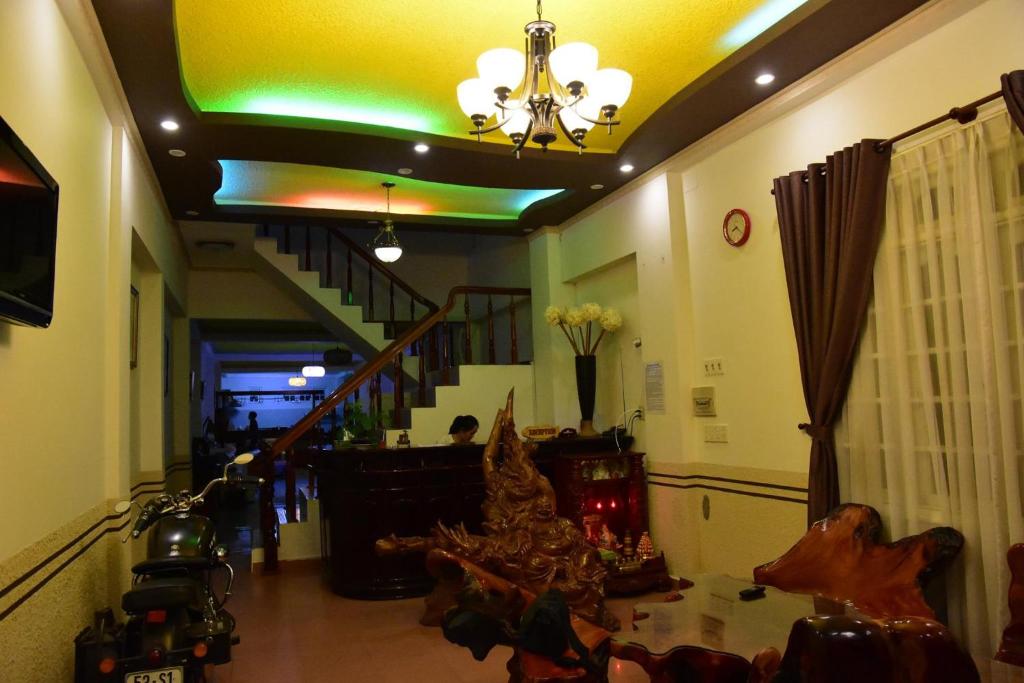 ein Wohnzimmer mit einer Treppe und einem Kronleuchter in der Unterkunft Vuon Hoa Hong (Rosary) in Da Lat