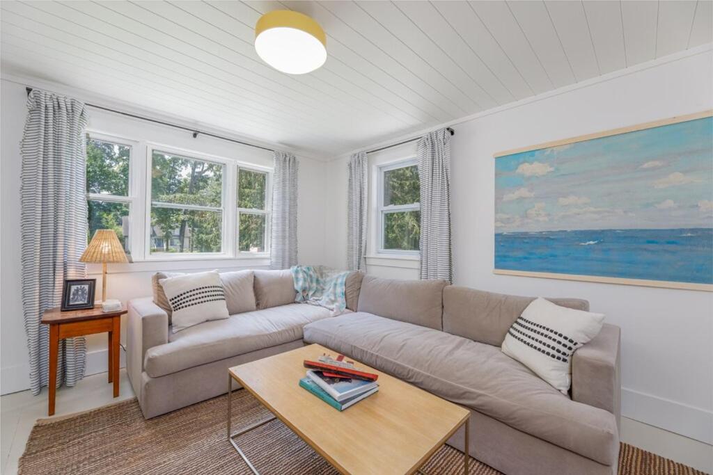 ケープ・メイにあるModern Coastal Farmhouseのソファとテーブルのあるリビングルーム