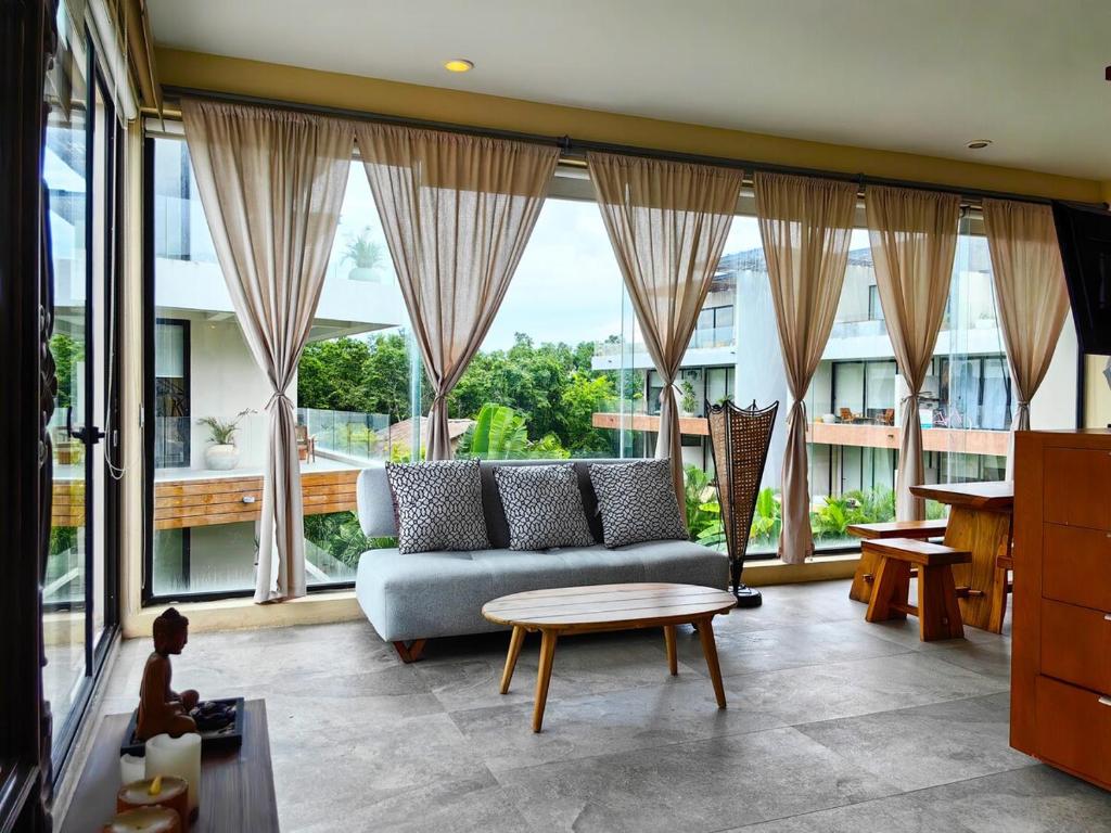 un salon avec un canapé et une table dans l'établissement Boho Chic Loft- Stunning Terrace in Central Tulum, à Tulum