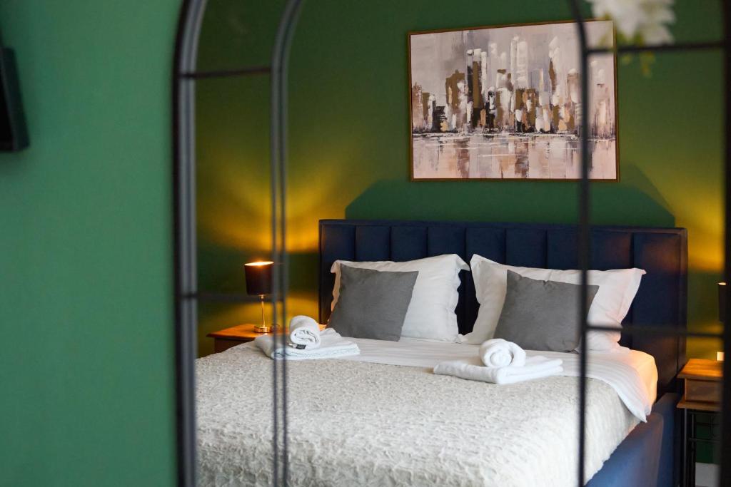 a bedroom with a bed with a green wall at Nest & Rest Apartment Fast Wi-Fi Free Parking in Braşov