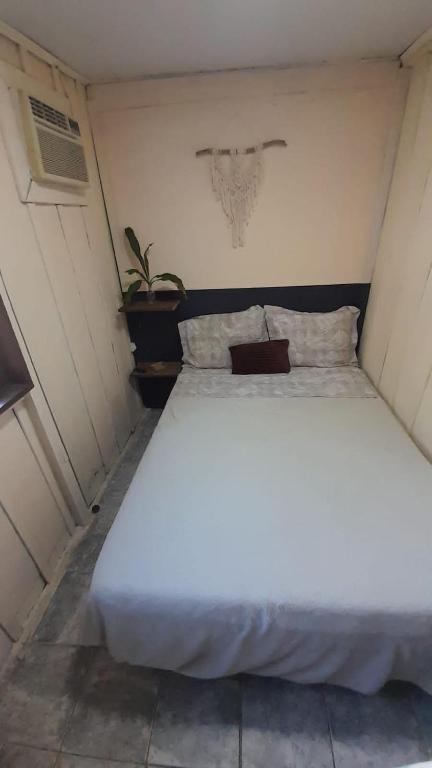 a large white bed in a small room at Recanto sem Saída in Paranaguá