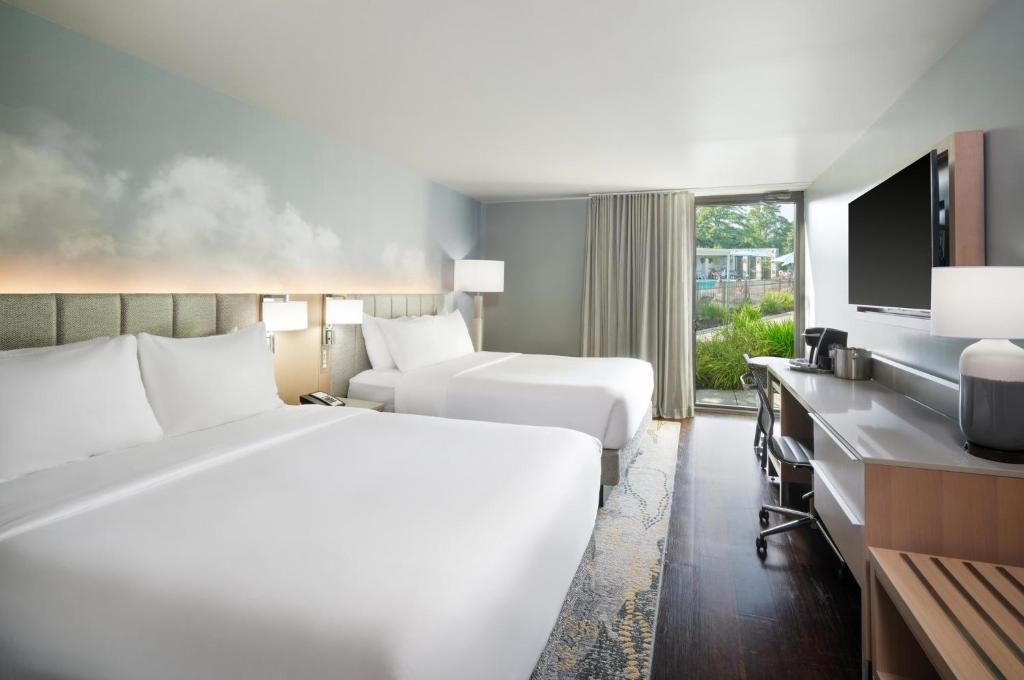 a hotel room with two beds and a television at Hotel Indigo Long Island - East End by IHG in Riverhead