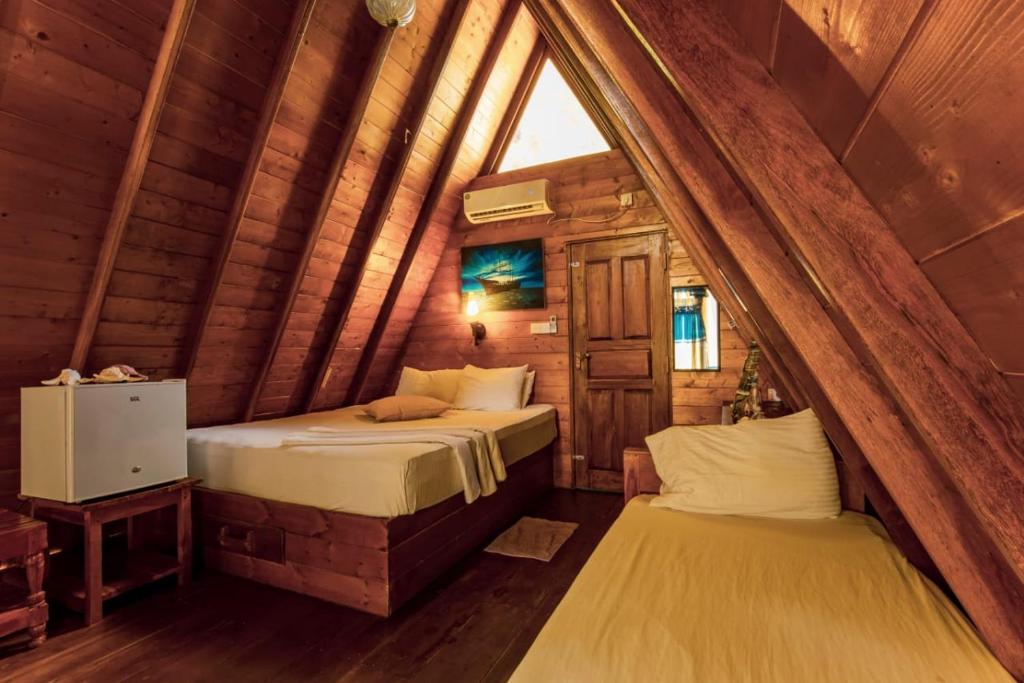 トリンコマリーにあるThats why sun & sea cabana nilaveliの丸太小屋のベッドが2つある寝室