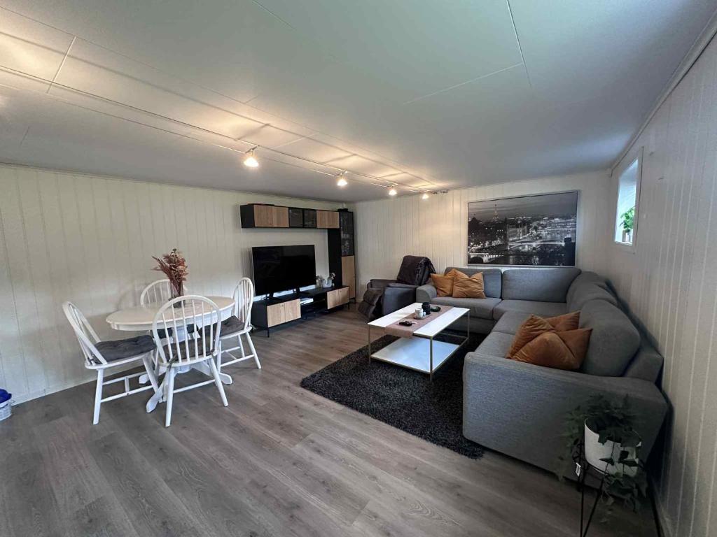 a living room with a couch and a table at Basement apartment in beautiful Volda in Volda