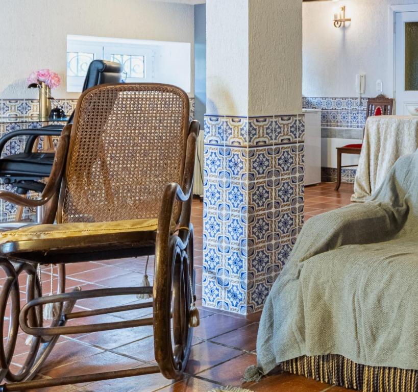a rocking chair sitting in a room with tiles at Vila Mar Beach House in Arcozelo