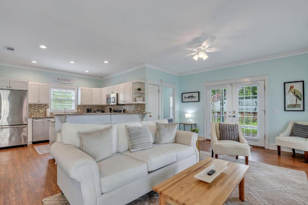 ein Wohnzimmer mit einer weißen Couch und einem Tisch in der Unterkunft Thunderbolt Bungalow by Lucky Savannah in Savannah