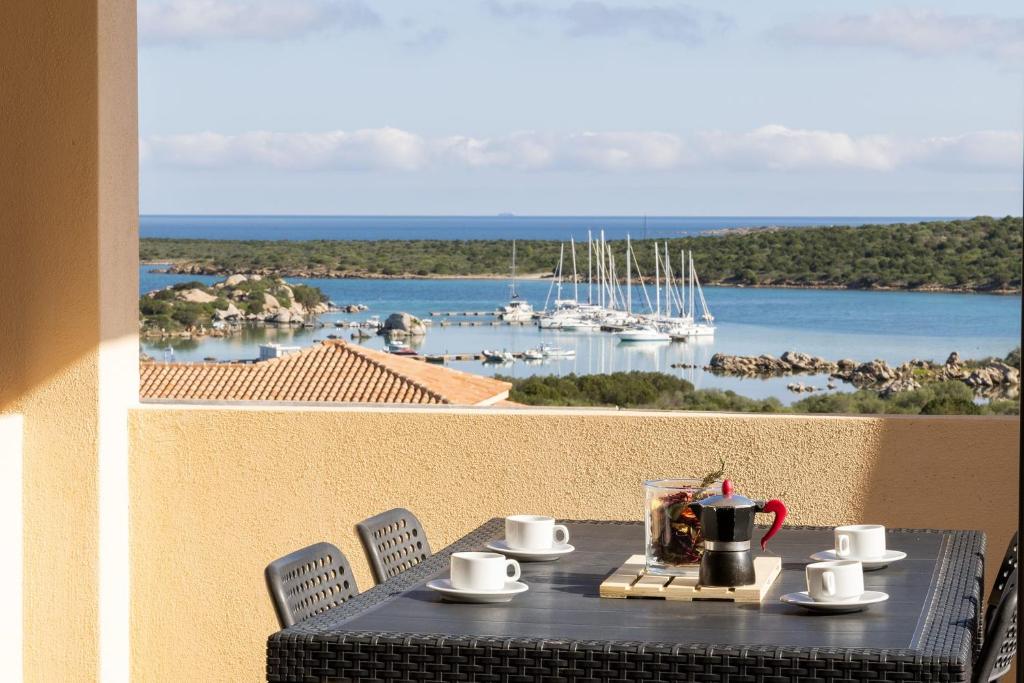 a table on a balcony with a view of a harbor at Relaxing BaiaDeBahas 1BedApt Bilo4 sleeps4 SeaView in Marinella