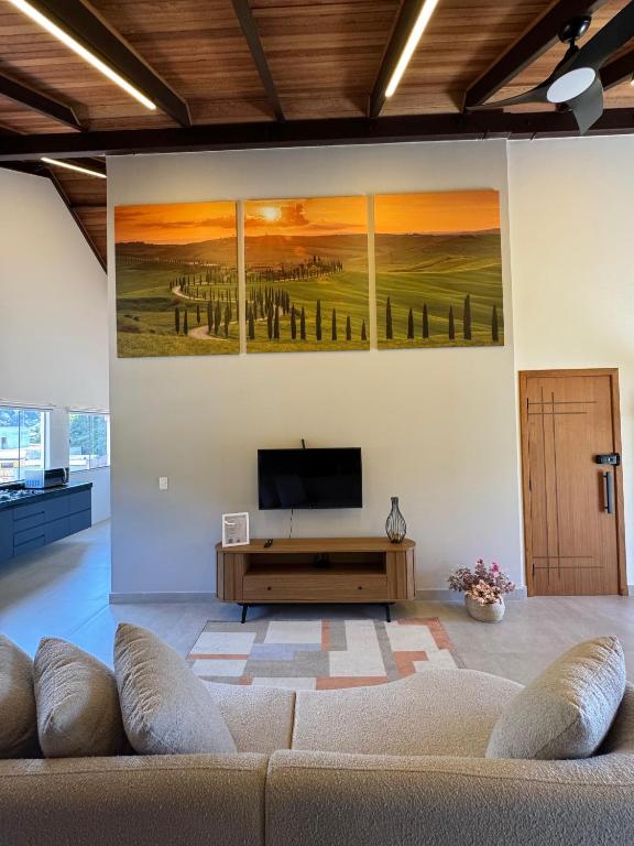 a living room with a couch and a tv on a wall at Loft Toscana in Santa Teresa
