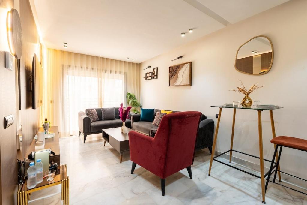a living room with a couch and a red chair at Awesome place with city view maarif casablanca in Maarif