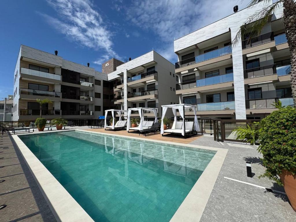 una piscina frente a un edificio de apartamentos en Apartment on Palmas Beach, en Governador Celso Ramos