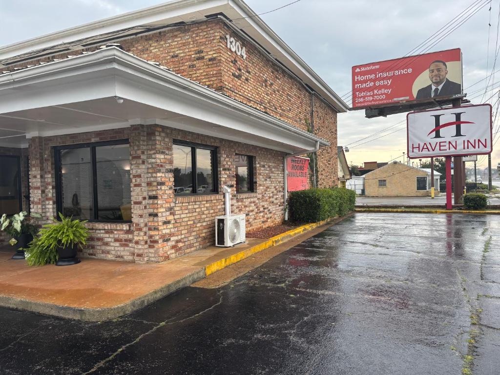 a brick building with a sign in front of it at Hotel O Haven Inn Huntsville AL US 72 in Huntsville