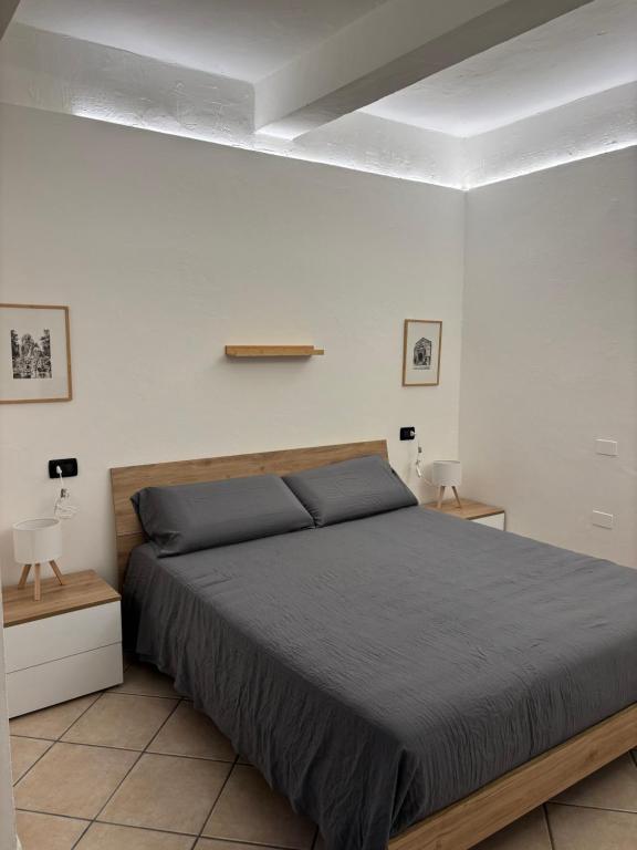 フェラーラにあるSottoSopra Apartments - In centro a piediの大きなベッドと2つのナイトスタンドを備えた寝室