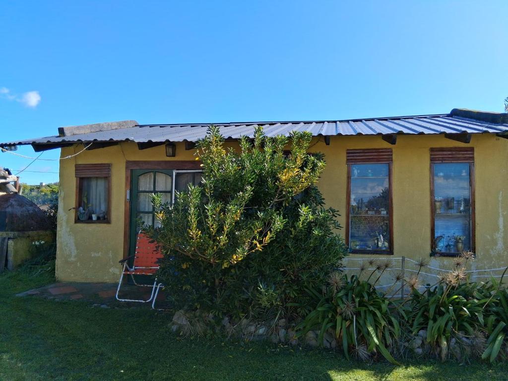 a yellow house with a tree in front of it at La Elegida in San Eduardo del Mar