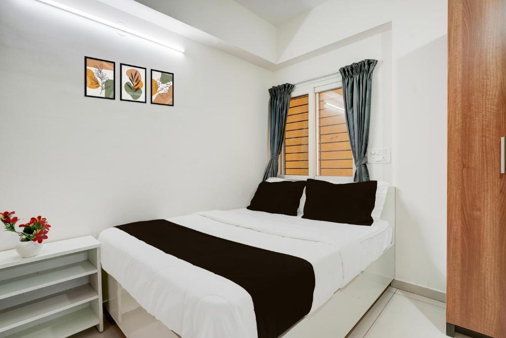 a white bedroom with a bed and a window at Hotel O Arrow Inn in Bengaluru