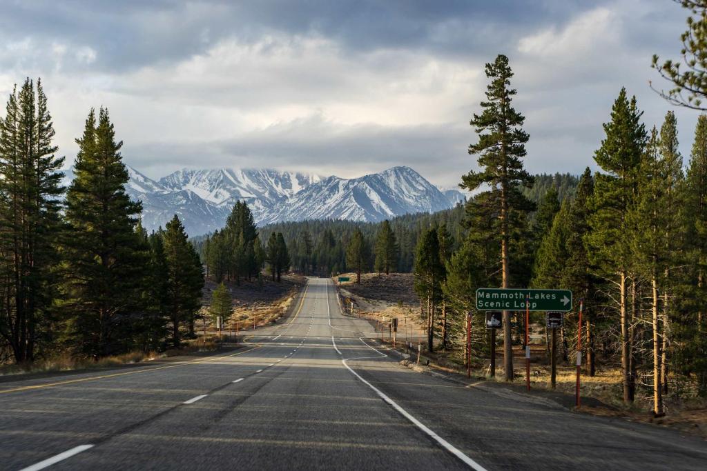 an empty road with snow capped mountains in the distance at Fireside Pool Access Hot Tub & More in Mammoth Lakes