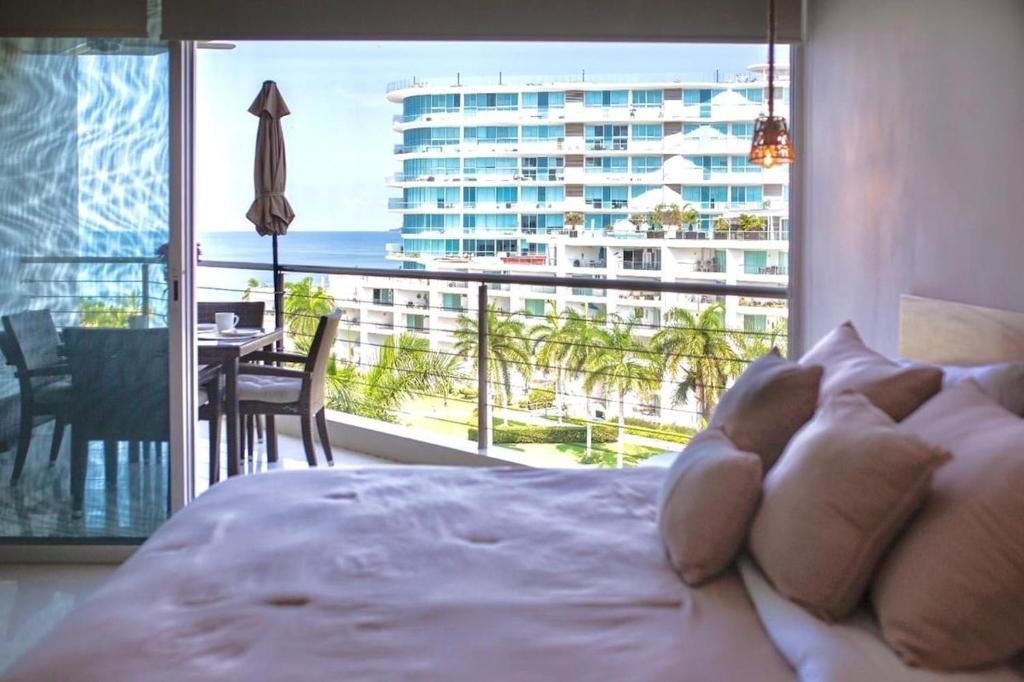 a bedroom with a bed with a view of a building at Ocean view - Studio in front of Nuevo Vallarta beach in Nuevo Vallarta 