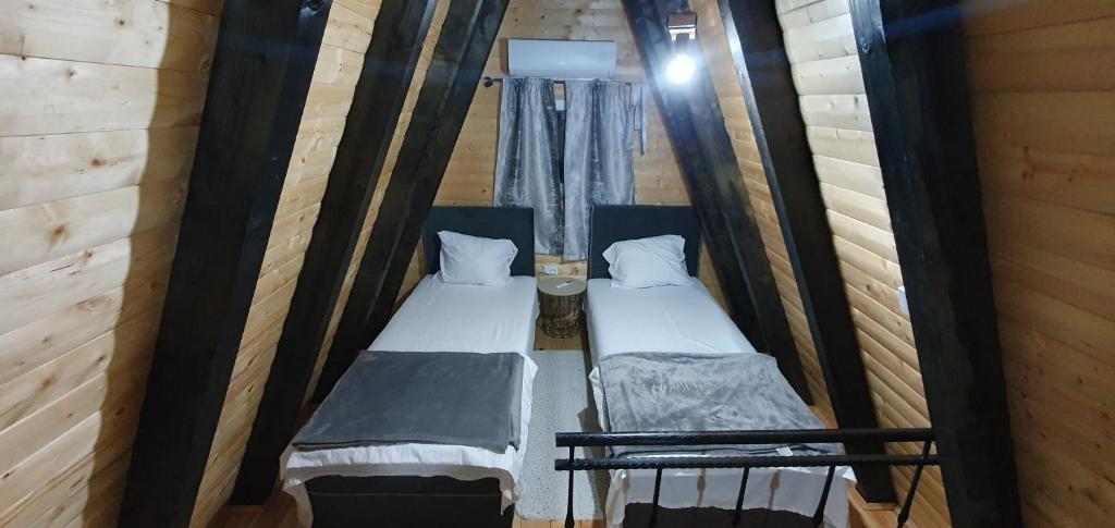 a room with two beds in a wooden cabin at Cozzy LUX apartment near the Airport Podgorica in Lajkovići