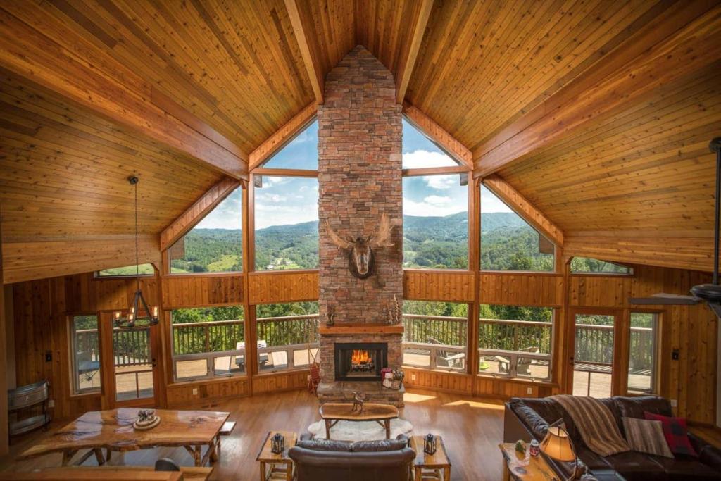 a large room with a fireplace in a log cabin at A-frame, Grand Views, Hot Tub, Mins To Boone & Asu in Sugar Grove