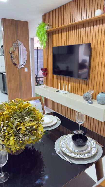 a dining room with a table with plates and a television at Refúgio de Luxo in Montes Claros