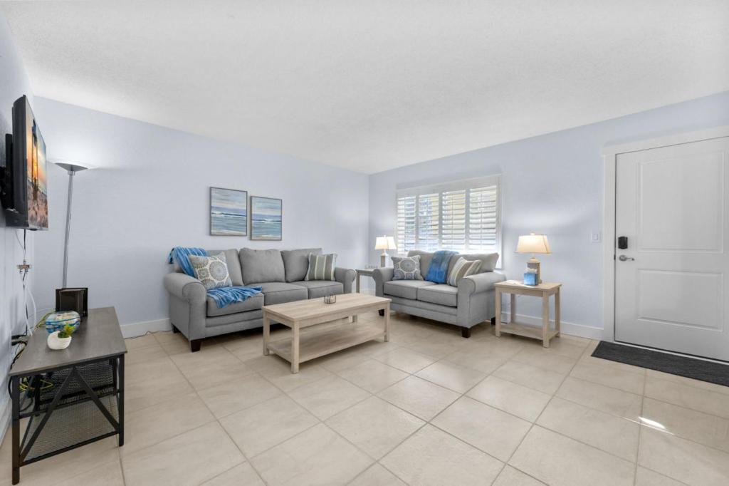 a living room with two couches and a table at Renovated 2-Bedroom Condo with Pool - The Waves in St. Pete Beach