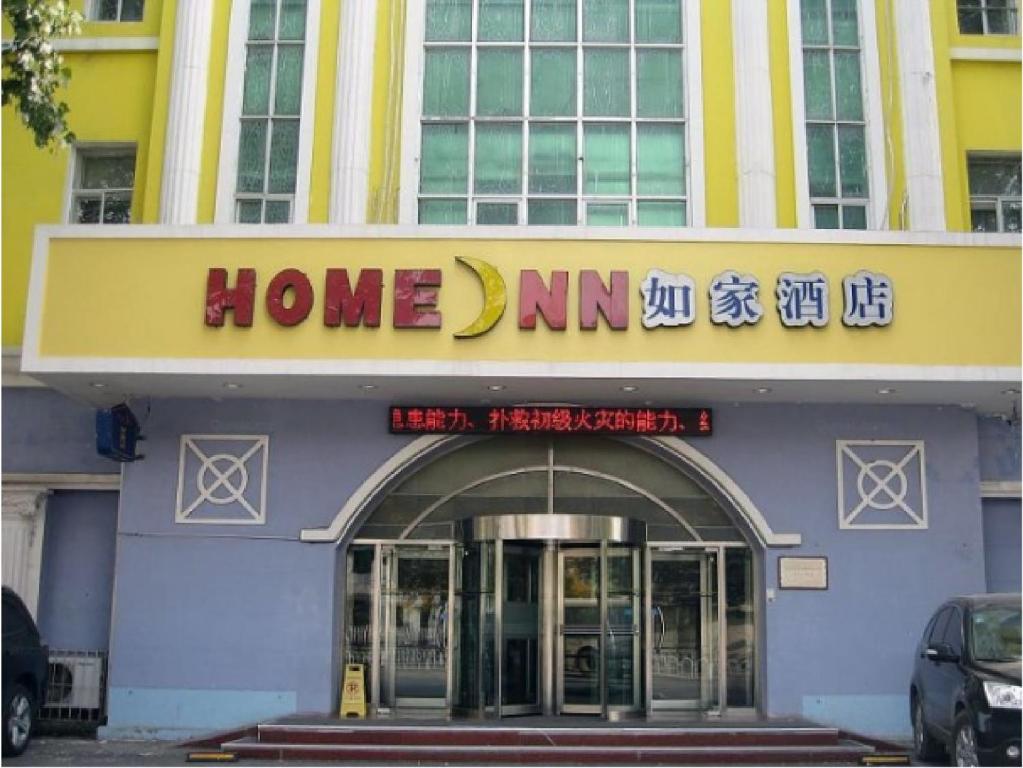 una señal de mamá en casa en la parte delantera de un edificio en Home Inn Shenyang Tiexi Xiangjiang, en Shenyang