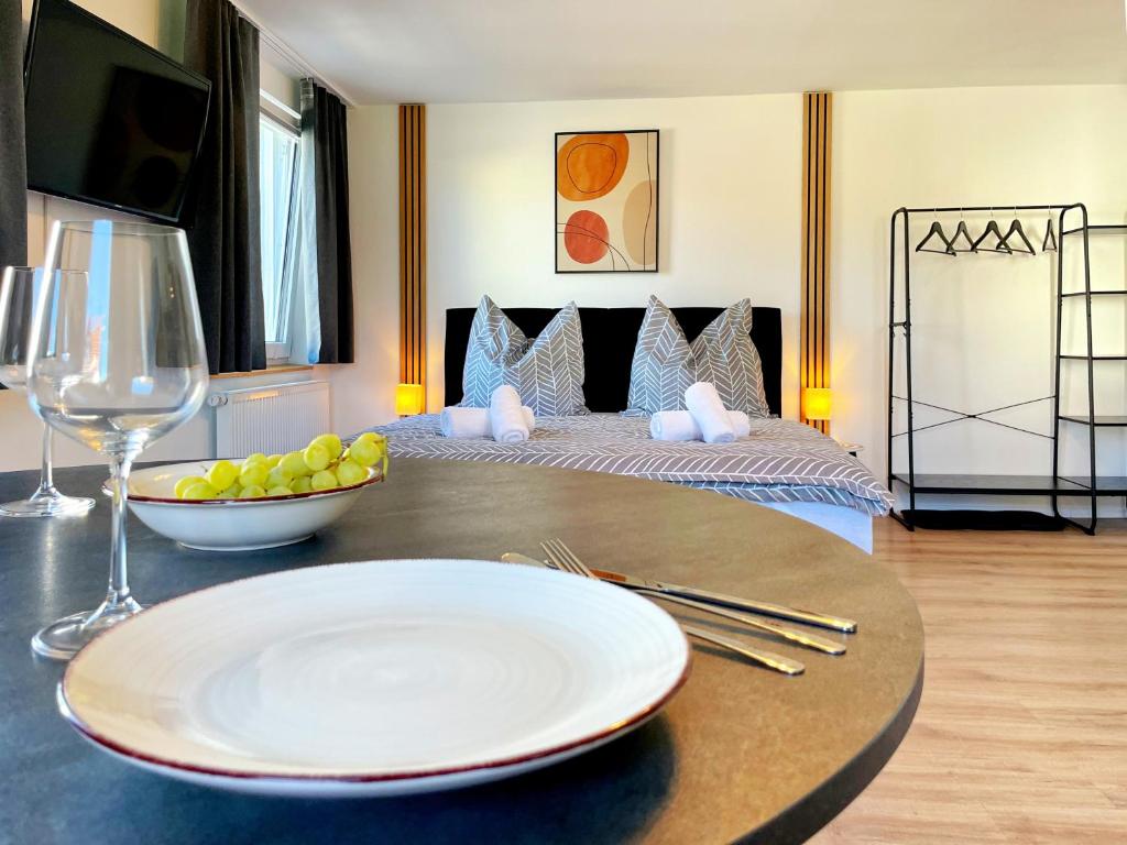 a table with a plate and a glass of wine at Apartment EverydayGood Erholung-Stadtnah-Anbindung-Einkauf-Biergarten in Salzweg