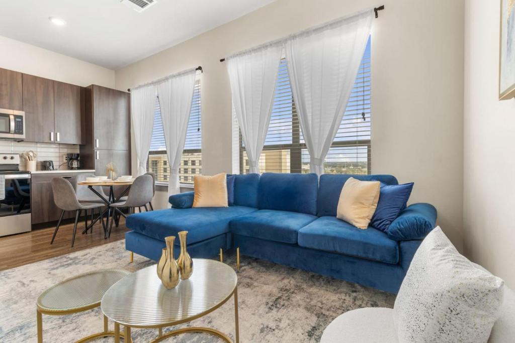 a living room with a blue couch and a kitchen at Cozy Hideaway, Rooftop Pool, Gym, Shops nearby in Georgetown