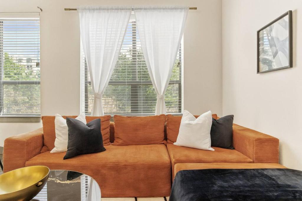 a couch sitting in a living room with windows at Modern Luxe Oasis, Rooftop Pool, Near Austin in Georgetown