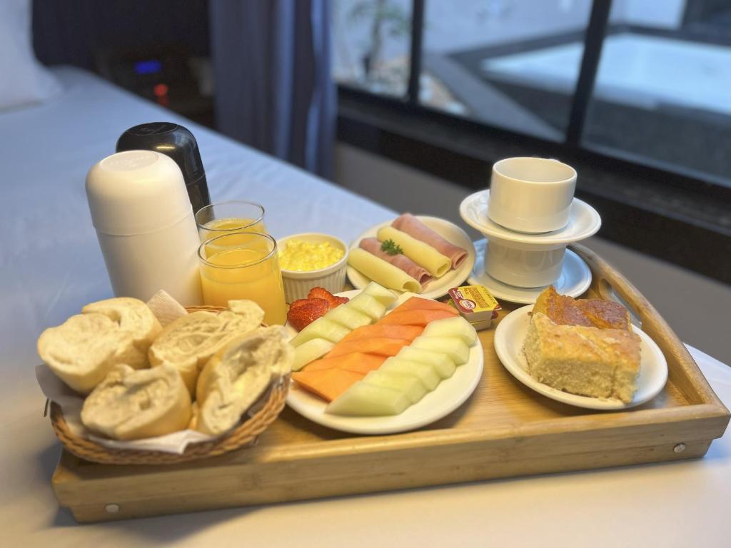 a tray of different types of food on a table at Status Elegance Hotel in Serra