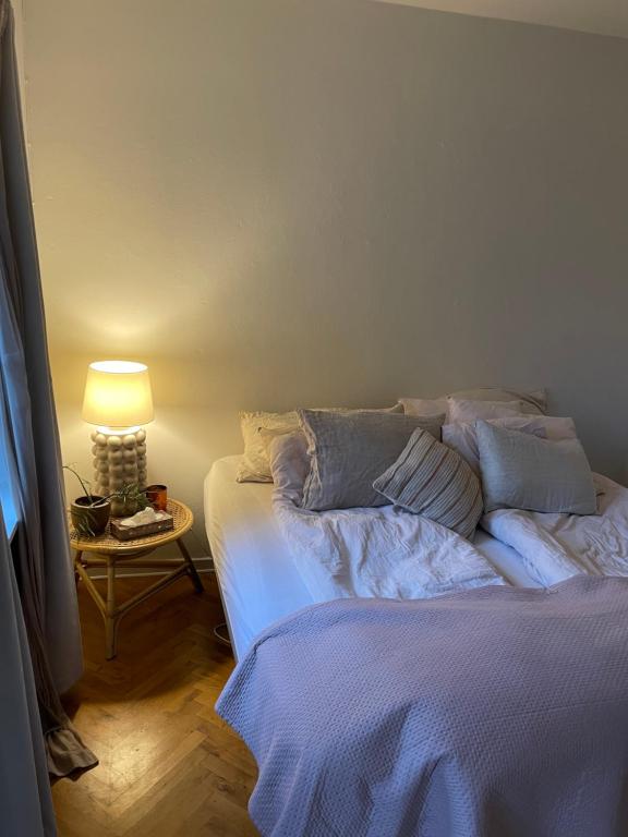 sypialnia z łóżkiem i stołem z lampą w obiekcie Stort værelse udlejes i herskabslejlighed midt i Odense by w mieście Odense