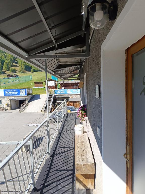 een balkon van een treinstation met een bankje bij Appartamento Guido Pina in Livigno